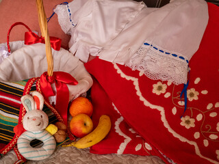Traje tradicional del sur de España en color rojo y bordado a mano con cesta de mimbre, fruta y juguete de conejo