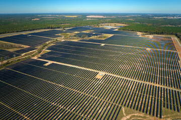 Aerial view of big sustainable electric power plant with many rows of solar photovoltaic panels for producing clean electrical energy. Renewable electricity with zero emission concept