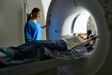 A dedicated female doctor guides a patient through a diagnostic MRI procedure in a hospital.