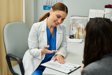 A gynecologist listens attentively while consulting a female patient about health concerns.