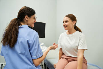 Obraz premium A gynecologist discusses health concerns with a patient in a contemporary medical clinic.