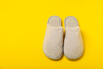 Soft slippers on a bright colored background, close-up. House slippers. Comfortable shoes for home. Foot care concept. Home comfort. Space for text. Copy space.