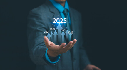 Business goals and vision 2025 a startup for success, businessman's hand with arrow graph showing...