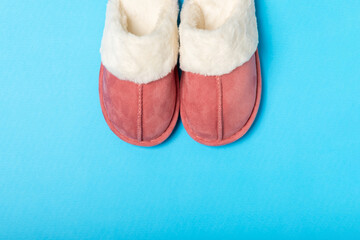 Soft slippers on a bright colored background, close-up. House slippers. Comfortable shoes for home. Foot care concept. Home comfort. Space for text. Copy space.