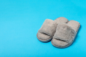 Soft slippers on a bright colored background, close-up. House slippers. Comfortable shoes for home. Foot care concept. Home comfort. Space for text. Copy space.
