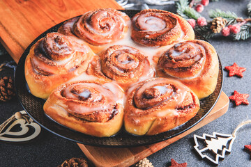 Cinnamon Rolls brioches or cinnamon rolls with icing sugar and cream cheese - decorated for Christmas
