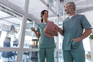 Fototapeta premium Two doctors walking in the clinic corridor and talking