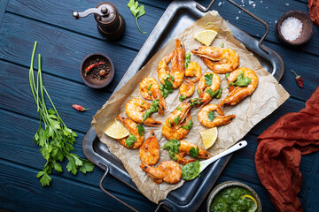  Fried shrimps with lemon and green on a metal tray, top view, copy space for text