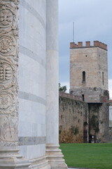 Medieval walls. Pisa city walls. Detail of the white marble baptistery and stone walls with towers. Italy