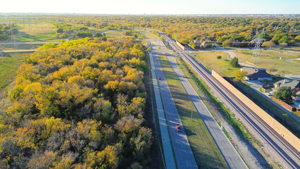 Lush greenery area colorful fall foliage in suburb Dallas Fort Worth with pylons over upscale...