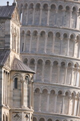 Medieval tower. Leaning Tower of Pisa. Details of the bell tower in Pisan Romanesque style with arches and columns in white Carrara marble. Italy