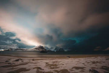 Northern lights illuminating snowy mountains in lofoten islands, norway