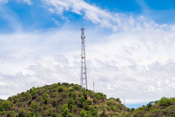 Telecommunication tower with antennas. Wireless Communication Antenna Transmitter with Mountains on...