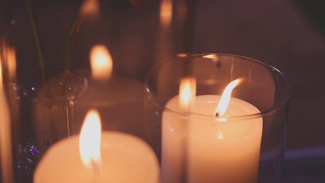 Beautiful candle scene with warm bokeh and white flowers for peaceful ambiance. An elegant candle scene with delicate white flowers and a soft, calming background.