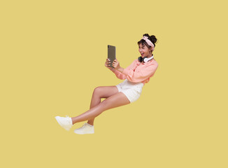 Young asian teenage girl hand holding computer tablet floating in mid-air isolated on yellow background. Fast internet and internet speed concept. © NaMong Productions