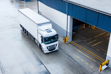 Truck parked at loading dock in industrial area during day
