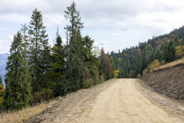 Obraz premium Dirt road in the autumn mountains