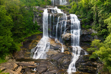 Fototapeta premium Whitewater Falls with falling down clear water from rocky boulders between green lush woods in Nantahala National Forest, North Carolina, USA