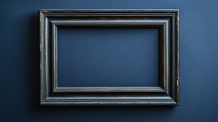 Fototapeta premium Empty vintage frame on dark blue wall, minimalistic interior concept.