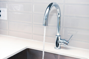water flows from stainless steel kitchen faucet