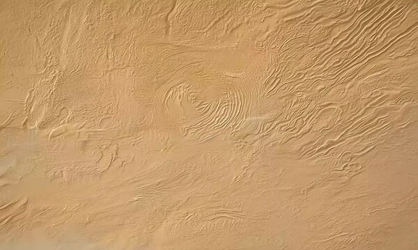 A textured surface resembling sand or desert terrain with subtle patterns and lines.