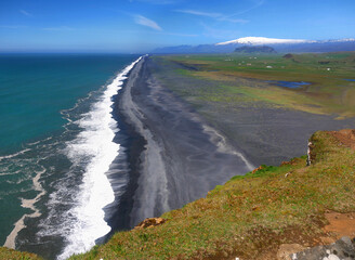 Iceland coastline from viewpoint. Sea waves on black beach.