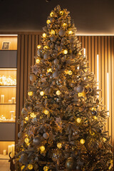 home christmas tree. The tree is decorated with colorful toys and a garland. Close-up photo in warm colors. Christmas and New Year atmosphere