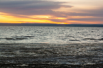 Obraz premium a sunset with clouds and a sunset on the horizon.