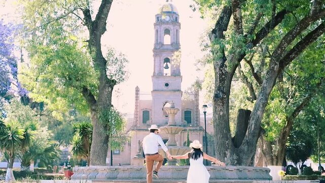 A couple having a romantic kiss in front of the San Miguel parish church in Temascalcingo, a Mexican village among the trees