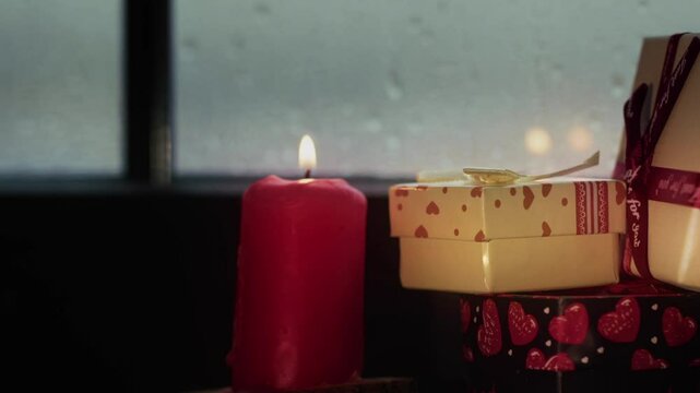 Holy Christmas New Year Eve Decoration and Gift Boxes on Candle Light Near the Window Glass in Rainy Day