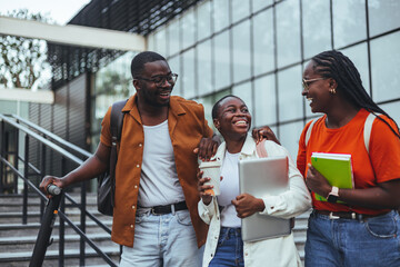 Smiling Friends Walking Together On Campus With Laptops And Notebooks
