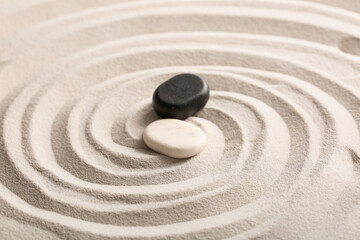 Obraz premium Stones on light sand with lines in Japanese rock garden. Zen concept