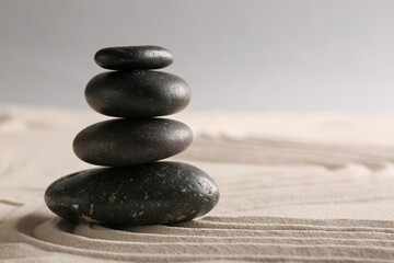 Stack of stones on light sand with pattern in Japanese rock garden. Zen concept