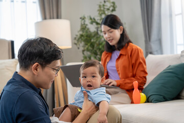 Obraz premium Asian baby and families who have to work while raising children at home