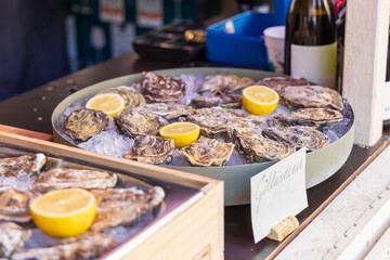 Oysters for eating are on the counter with lemon for sale. Street sale