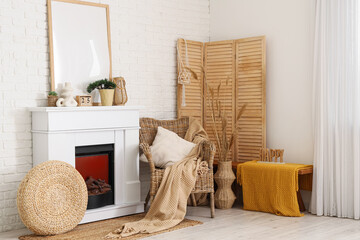 Interior of living room with wooden folding screen, armchair and fireplace