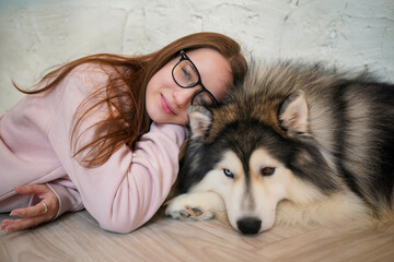 Woman with a husky in a snowy portrait scene showing a close bond with a beautiful Siberian Husky featuring striking blue eyes