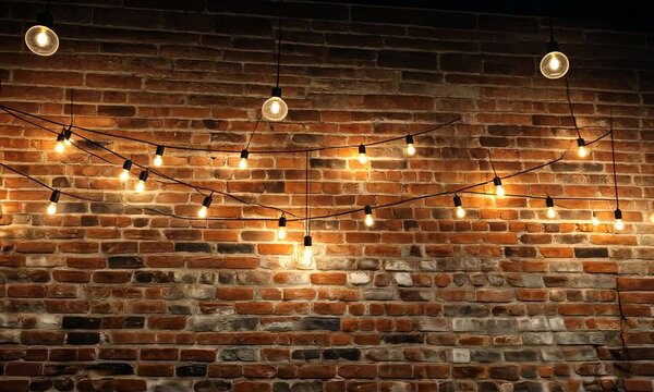 Warm ambiance fills cozy brick wall cafe adorned with glowing vintage lights at night