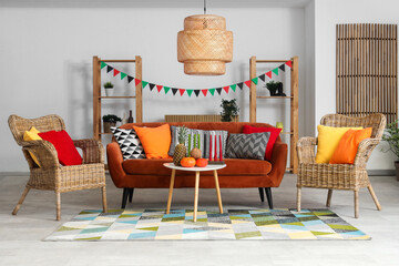 Interior of living room decorated for Kwanzaa celebration with red sofa, armchairs and table