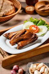 Bebek Goreng, Traditional Fried Duck. Popular Menu came from Madura, East Java. served with sambal, cucumber, tomato and lettuce.