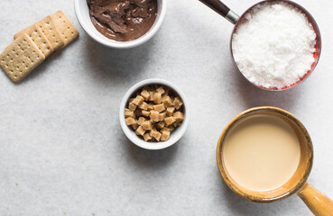 Overhead view of mise en place for making chocolate fudge with cookies and fudge pieces, Top view of ingredients of hazelnut chocolate fudge