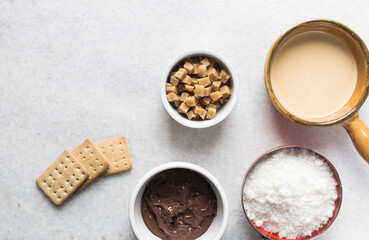 Overhead view of mise en place for making chocolate fudge with cookies and fudge pieces, Top view of ingredients of hazelnut chocolate fudge