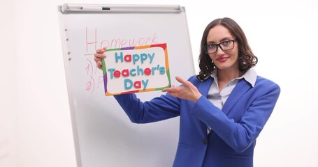 Young woman English teacher holds congratulatory card with Teacher Day. Tutor celebrates professional holiday and enjoys festive atmosphere slow motion