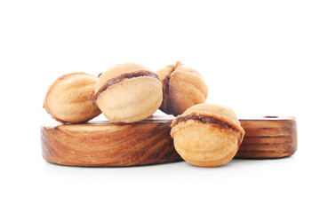 Wooden board of sweet walnut shaped cookies with boiled condensed milk on white background