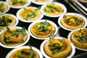 A close-up of quiche, which is a French tart consisting of a pastry crust filled with savoury custard and pieces of cheese, meat, seafood or vegetables