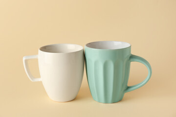 Different ceramic cups on yellow background