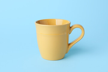 Yellow empty ceramic mug on blue background