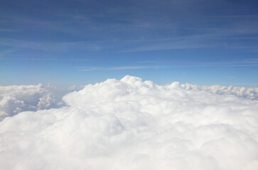 Fototapeta premium fluffy clouds seen from above from a flying plane and the blue sky above