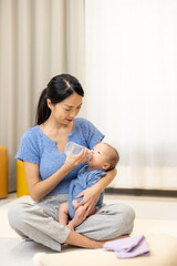 Fototapeta premium Mother feeding newborn baby with milk bottle
