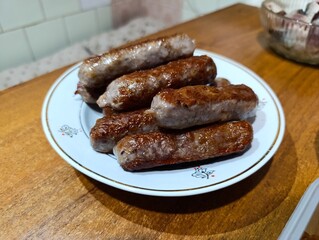 A plate of sausages sitting on top of a wooden table